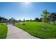 A neighborhood park offers a sunny playground with various slides, swings, and climbing structures set on a green lawn at 5481 E 117Th Ave, Thornton, CO 80233