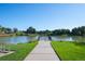 Picturesque pond view from a wooden pier with a picnic bench and lush green surroundings at 5481 E 117Th Ave, Thornton, CO 80233