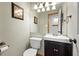 Compact powder room with dark vanity and decorative lighting at 5481 E 117Th Ave, Thornton, CO 80233