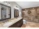 Bathroom featuring double sinks, a luxurious walk-in shower, and neutral tile design at 5625 Twilight Way, Parker, CO 80134