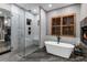 Modern bathroom with walk-in shower, soaking tub, tiled floors, and natural wood accents at 5625 Twilight Way, Parker, CO 80134