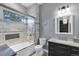 Bright bathroom featuring marble tiling in the shower and vanity with a crystal chandelier at 5625 Twilight Way, Parker, CO 80134