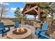 Outdoor fire pit and lounge area with blue Adirondack chairs under a timber-framed pavilion at 5625 Twilight Way, Parker, CO 80134