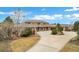 Front exterior showcases circular driveway and lush landscaping leading up to the grand residence at 5625 Twilight Way, Parker, CO 80134