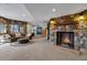 Cozy living room with stone fireplace, plush seating, and rustic accents with carpet floors at 5625 Twilight Way, Parker, CO 80134