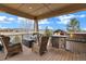 Covered outdoor patio area with comfortable seating, gas grill, small refrigerator, and beautiful views at 5625 Twilight Way, Parker, CO 80134