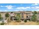 Rear exterior view of a large home with multiple decks, patios, stone accents, and mature landscaping at 5625 Twilight Way, Parker, CO 80134