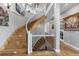 Elegant staircase with custom wood treads and a wrought iron railing, bathed in natural light at 5625 Twilight Way, Parker, CO 80134