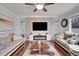 Spacious living room featuring a modern fireplace and built-in shelving at 2946 S Espana Ct, Aurora, CO 80013