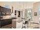 Modern kitchen with dark cabinetry, granite countertops, and an island with bar seating at 12114 Alcott St, Westminster, CO 80234