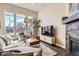 Bright living room featuring large windows, modern furnishings, and a cozy fireplace at 12114 Alcott St, Westminster, CO 80234