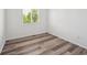 A bright bedroom with a large window and attractive, light-colored laminate flooring at 9697 Marmot Ridge Cir, Littleton, CO 80125