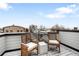 Balcony with two wooden chairs featuring wintery city views on a sunny day at 3520 W Connejos Pl # 5, Denver, CO 80204