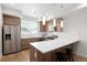 Modern kitchen with stainless steel appliances, wooden cabinets, and a center island with seating at 3520 W Connejos Pl # 5, Denver, CO 80204
