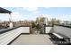 Relax on this rooftop deck with panoramic city views, offering a perfect spot for entertaining and enjoying the outdoors at 3520 W Connejos Pl # 5, Denver, CO 80204