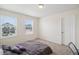 Bright bedroom featuring neutral carpet, two windows with blinds and a large, comfy bed at 1143 Williams Loop, Elizabeth, CO 80107