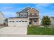 Charming two-story home showcasing a stone and siding facade with a three-car garage and manicured lawn at 1143 Williams Loop, Elizabeth, CO 80107