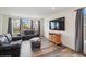 Comfortable living room featuring hardwood floors, a plush sofa, and a large flat-screen TV at 1143 Williams Loop, Elizabeth, CO 80107