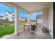 Covered front porch with gray wood flooring, white columns and a table with chairs at 1143 Williams Loop, Elizabeth, CO 80107