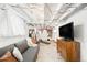 Finished basement living room featuring a comfortable couch, exposed ductwork and bright lighting at 534 S Pearl St, Denver, CO 80209