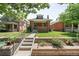 Inviting brick home with landscaped front yard, steps to front door, and mature shade trees at 534 S Pearl St, Denver, CO 80209