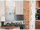 Home office with wood desk, computer setup, brick accent wall, and coffee station at 534 S Pearl St, Denver, CO 80209