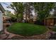 Spacious backyard featuring a well-manicured lawn, mature trees, and various outdoor structures at 2684 Taft Ct, Lakewood, CO 80215