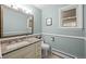 Well-lit bathroom featuring a vanity with granite countertop and a framed mirror at 2684 Taft Ct, Lakewood, CO 80215