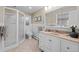 Bright bathroom featuring a walk-in shower, neutral tile flooring, and a vanity with white cabinets at 2684 Taft Ct, Lakewood, CO 80215