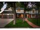Charming two-story home features a brick and white facade, attached garage, and a beautiful green lawn at 2684 Taft Ct, Lakewood, CO 80215