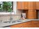 Close-up of a kitchen sink with stylish backsplash, granite countertops, and modern fixtures at 2684 Taft Ct, Lakewood, CO 80215