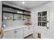 Bright laundry room with storage cabinets, open shelving, and access to the backyard at 2684 Taft Ct, Lakewood, CO 80215