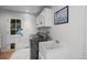 Functional laundry room with modern washer and dryer, utility sink, and convenient access to the backyard at 2684 Taft Ct, Lakewood, CO 80215