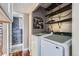 Efficient laundry area with modern appliances, overhead storage, and stylish decor elements at 4400 S Quebec St # 101N, Denver, CO 80237