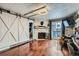 Comfortable living room features a stone fireplace, barn door, and shiny hardwood floors at 4400 S Quebec St # 101N, Denver, CO 80237