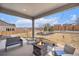 Backyard features a fire pit, manicured lawn, stone landscaping, patio and seating at 11346 Kittredge St, Commerce City, CO 80022