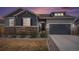 Charming home exterior featuring a stone facade, two-car garage, and manicured landscaping at 11346 Kittredge St, Commerce City, CO 80022