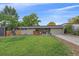 The home's front exterior features a well-kept lawn, mature trees, and a welcoming porch at 7911 Raleigh Pl, Westminster, CO 80030