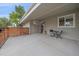 Covered front patio featuring a small table, chairs and decor, with a nice wood accent feature at 7911 Raleigh Pl, Westminster, CO 80030