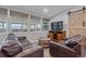 Cozy living room showcasing a leather sofa, wood accents, and great light from plentiful windows at 7911 Raleigh Pl, Westminster, CO 80030