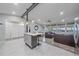 Open-concept living space with a modern kitchen island and a comfortable living area with leather sofas at 7911 Raleigh Pl, Westminster, CO 80030