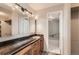 Well-lit bathroom featuring a granite countertop vanity, wood cabinets and a shower-over-tub with modern tile at 955 Eudora St # 1107, Denver, CO 80220