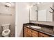 Cozy bathroom with a granite-topped vanity, warm wood cabinets, and a toilet in a private space at 955 Eudora St # 1107, Denver, CO 80220