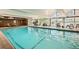Spacious indoor pool with a glass ceiling and large windows, surrounded by lounge chairs and plants at 955 Eudora St # 1107, Denver, CO 80220