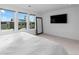 Bright bedroom featuring three windows, a full length mirror, and a wall mounted TV at 3646 Quivas St, Denver, CO 80211