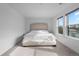 Minimalist bedroom with a large upholstered bed and natural light from two windows at 3646 Quivas St, Denver, CO 80211