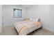 Well-lit bedroom featuring carpeted floors, a bed with an orange and gray blanket, and a neutral color scheme at 3646 Quivas St, Denver, CO 80211