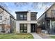 Striking front elevation of modern home featuring clean lines, gray siding, and stone accents at 3646 Quivas St, Denver, CO 80211