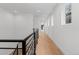 Long, bright hallway with hardwood floors and black metal railings overlooking the staircase at 3646 Quivas St, Denver, CO 80211