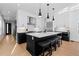 Modern kitchen featuring a large island, breakfast bar seating, stainless steel appliances, and white cabinetry at 3646 Quivas St, Denver, CO 80211